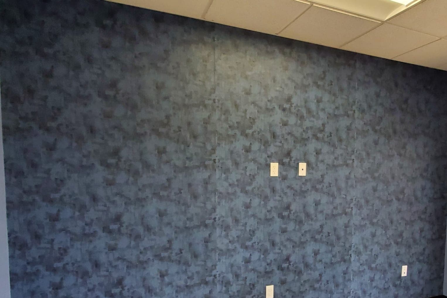 A textured blue-grey paper, outlets uncovered, before the trim goes back on